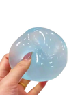 A translucent light blue moldable slow rebound stress ball with subtle internal swirls and a smooth glossy surface view