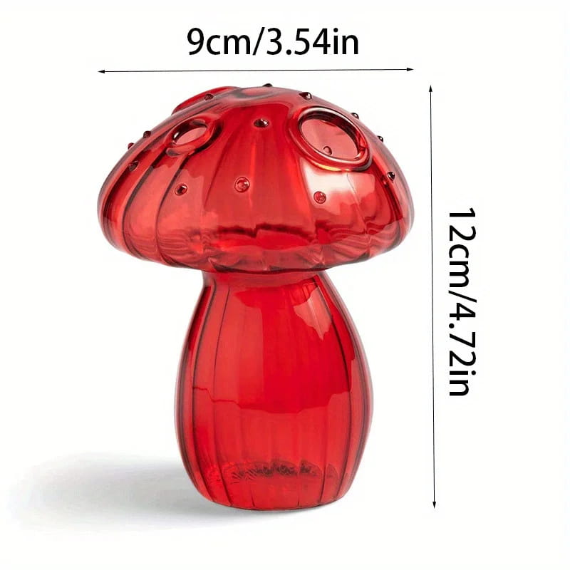 A translucent red glass mushroom-shaped bud vase with a glossy finish and detailed ridges serving as a colorful Nordic plant holder.