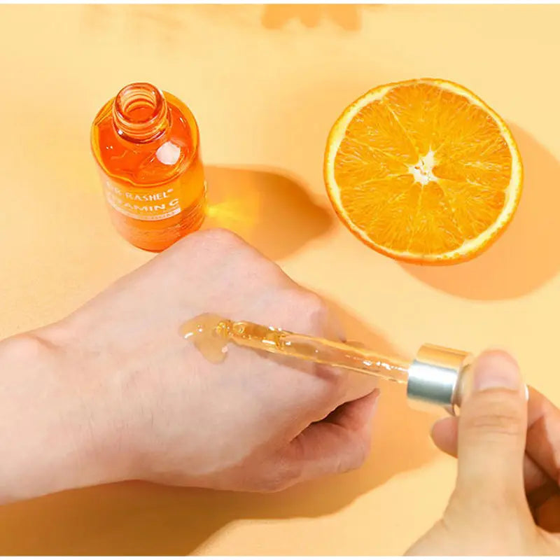 A clear glass dropper bottle with a silver cap filled with amber-colored liquid from the vitamin c brightening skincare set.