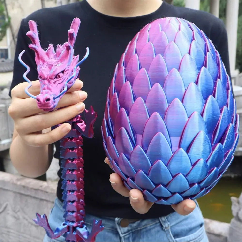 A vibrant pink and blue gradient 3d-printed giant dragon figurine with detailed scales, horns, and a segmented spine displayed from the front as part of a 3d printed giant dragon egg and figurine set.