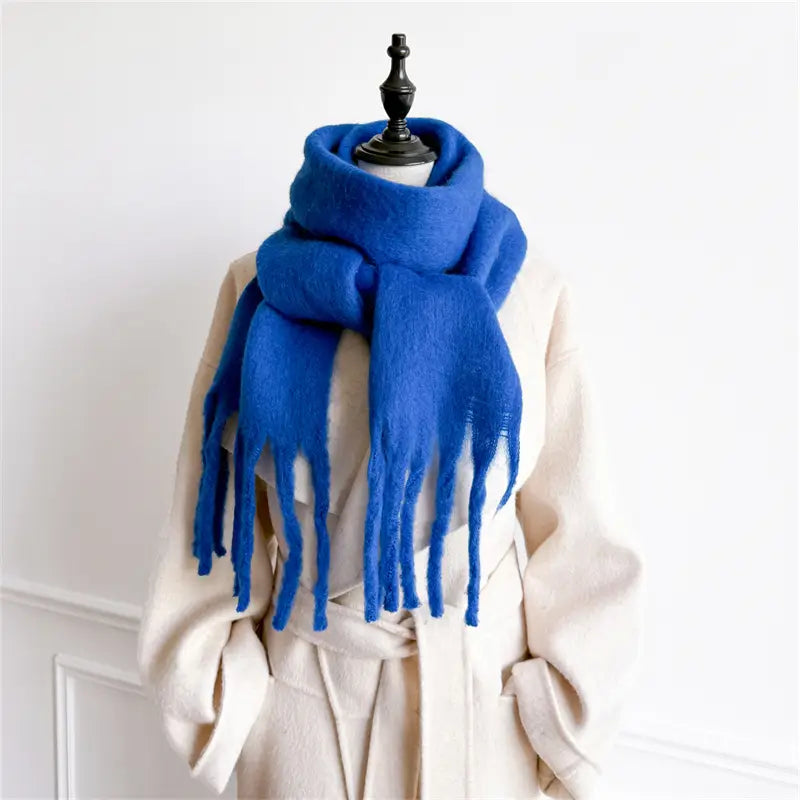 Ein leuchtend königsblauer Damenschal mit Cashmere-ähnlichem Gefühl für den Winter aus plushigem, wolligem Material mit weichen, gefransten Enden.