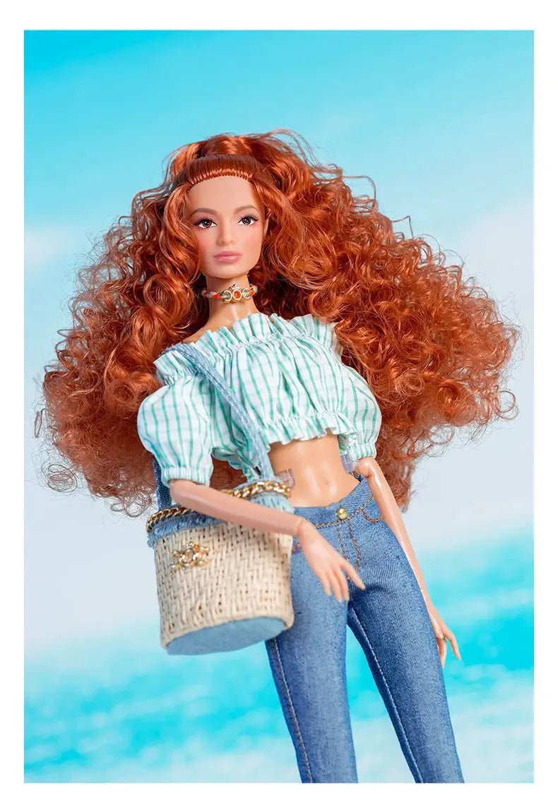 Ensemble de vêtements et d’accessoires de mode pour poupée à l’échelle 1/6, comprenant une poupée Barbie aux cheveux auburn bouclés volumineux, portant un haut court à épaules dénudées à rayures bleu clair et blanc et un jean en denim.
