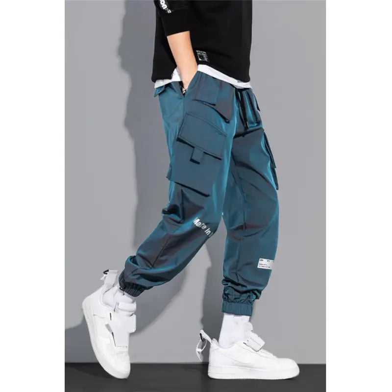 Teal mens tactical cargo pants with multiple pockets and a drawstring waistband designed for streetwear.
