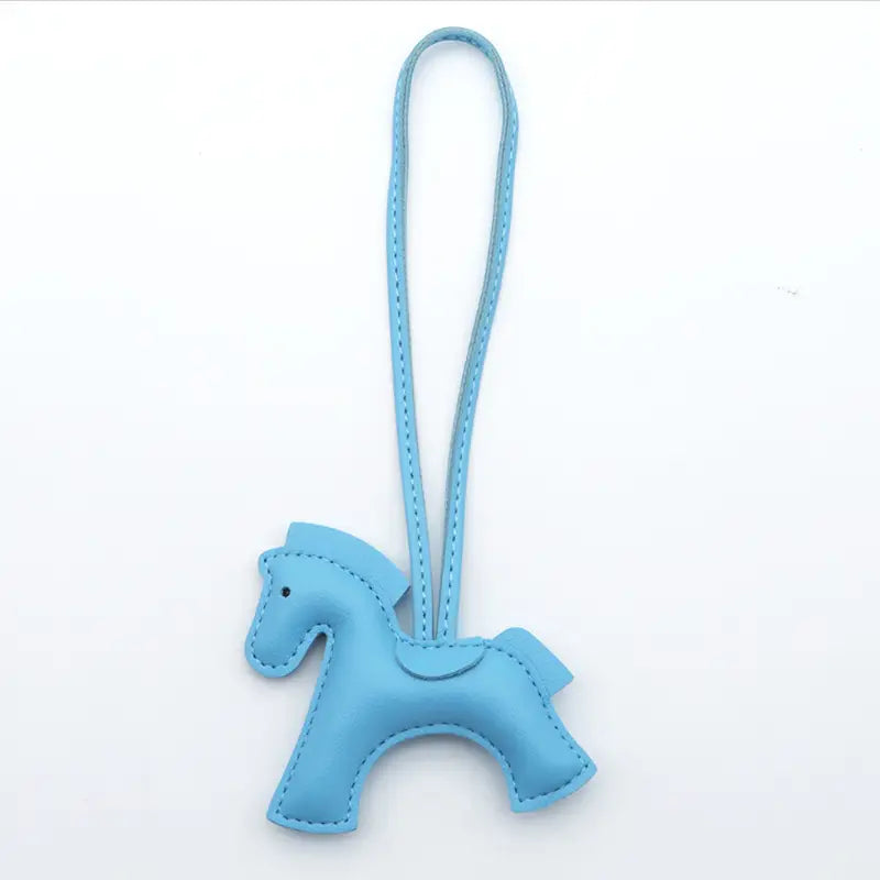 Porte-clés en cuir bleu clair en forme de cheval avec détails cousus et une lanière assortie.