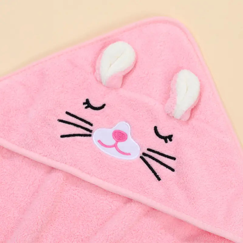 Toalla de baño para bebé con capucha suave y esponjosa color rosa, hecha de algodón suave para envolver, con una carita de conejito bordada con orejas blancas, bigotes negros y una nariz rosa.
