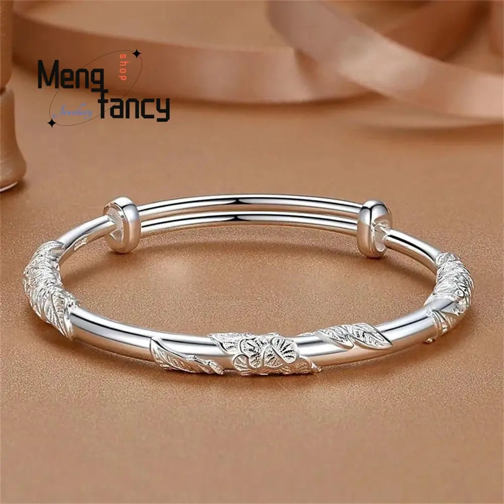 silver bangle bracelet with intricate leaf and floral engravings and a polished finish featuring natural jade raw stone in a floral sliding design