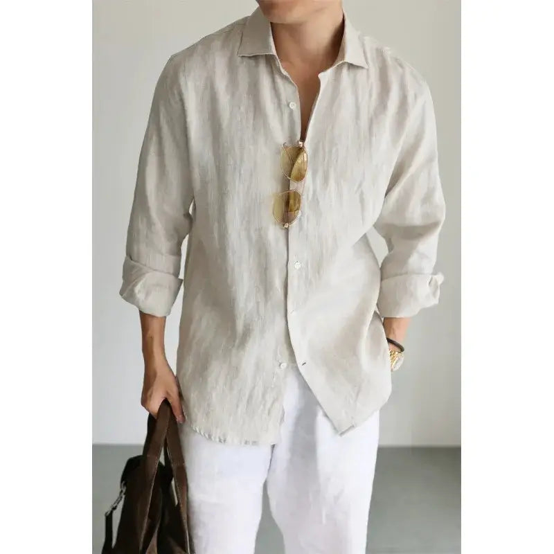 A light beige men cotton linen casual button down shirt with long sleeves, rolled cuffs, and a collar.