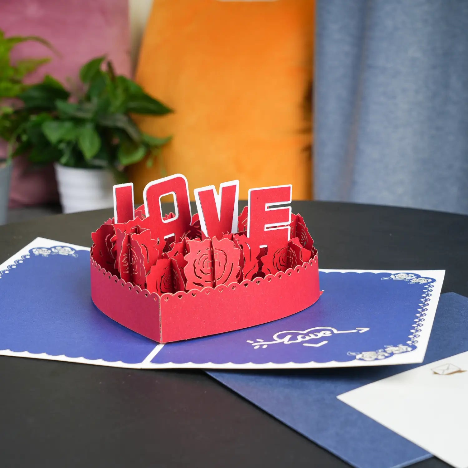 Carte de la Saint-Valentin 3D à effet pop-up en papier découpé rouge, richement travaillée, avec le mot « love » et des motifs de rose pour salutation en couple romantique.