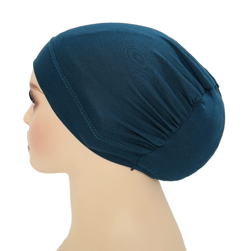 A soft deep teal stretchy jersey sleep cap with smooth fabric finish and subtle seam detailing designed for hijab and turban wear.