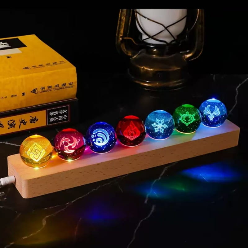 Une base en bois portant sept sphères de verre translucides et lumineuses avec des motifs gravés complexes et des lumières LED intégrées, comme produits finis de la boule de cristal de Genshin Impact.