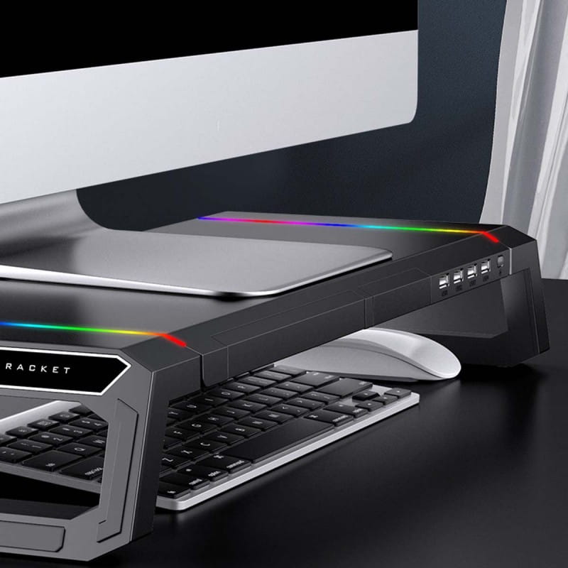 Support de moniteur RGB noir de marque raquette avec station d’accueil USB intégrée et tiroir de rangement, doté d’un éclairage à LED arc-en-ciel le long de ses bords.