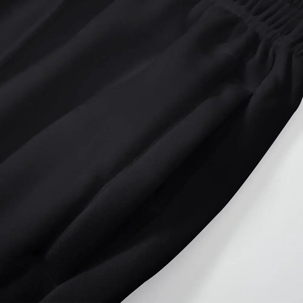 Pantalons cargo noirs pour homme à coupe ample de style jogging, taille élastique, avec une texture de tissu doux et lisse.