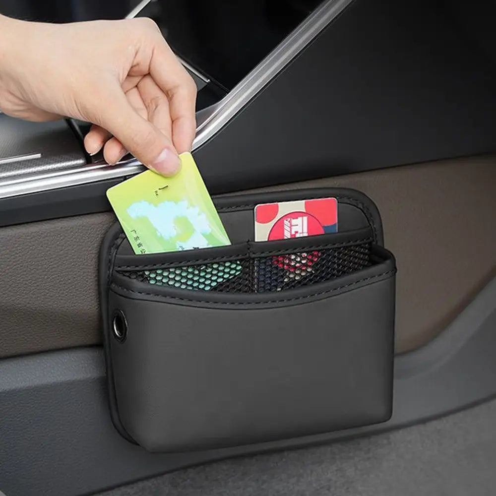 Pochette de rangement pour voiture noire avec adhésif en similicuir, organisateur avec poches en maille et petite boucle métallique pour la fixation.