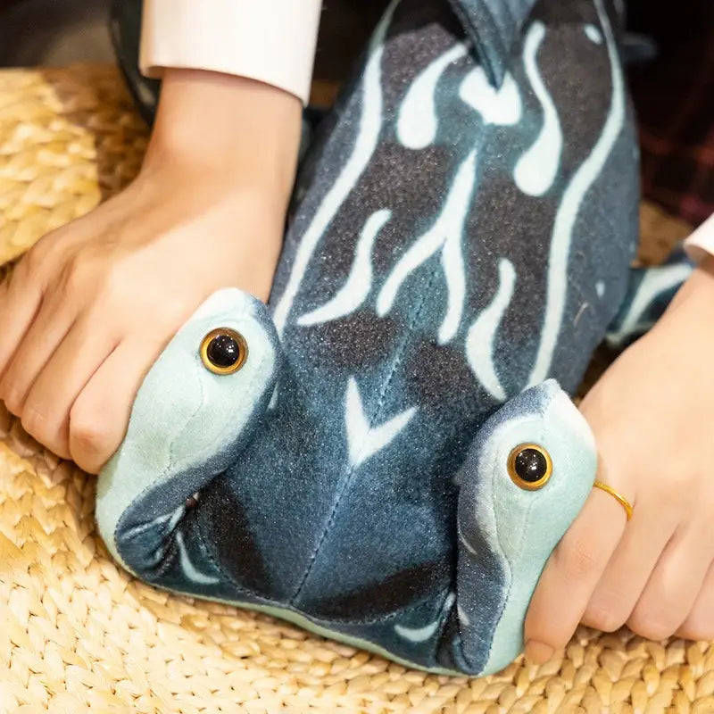 Plush blue and white frog-shaped slipper with embroidered eyes featured alongside a hammerhead shark plush pillow soft toy.