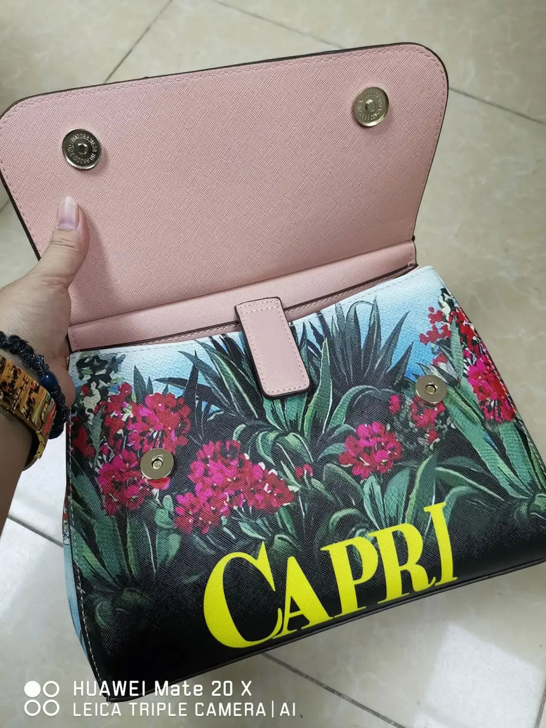 Sac bandoulière en cuir vintage, art raffiné, avec un imprimé floral rose et noir, des lettres « Capri » jaunes, une quincaillerie ton or et un extérieur texturé.