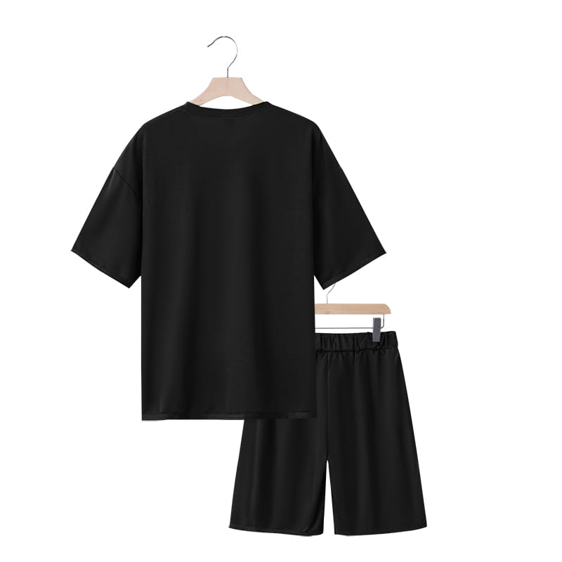 Conjunto veraniego de dos piezas para hombre en algodón negro, que consta de una camiseta casual de manga corta y ajuste relajado, combinada con pantalones cortos con cinturilla elástica.