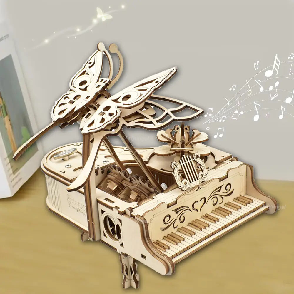 ein zartes, hellfarbenes hölzernes Schmetterlingsmotiv, das auf einem kunstvoll gestalteten mechanischen Klavier-Musikbox-Modell aus der 3D-Holz-Puzzle-Bastelset-Anleitung thront