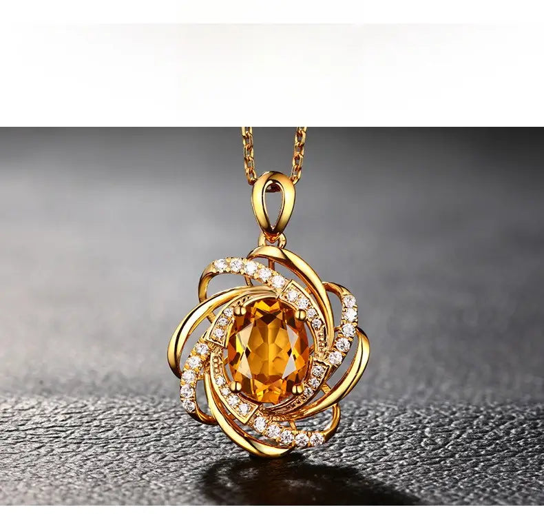 Collier pendentif moulin à vent en citrine en or comportant une citrine ovale centrale entourée de bandes dorées tourbillonnantes, de petits diamants et suspendue à une chaîne dorée ornée.