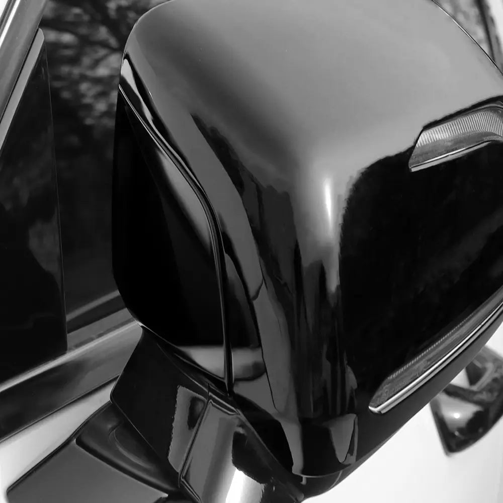 Black glossy side mirror with integrated led turn signal showing the back side, part of Hyundai Palisade led mirror covers for 2020-2025.