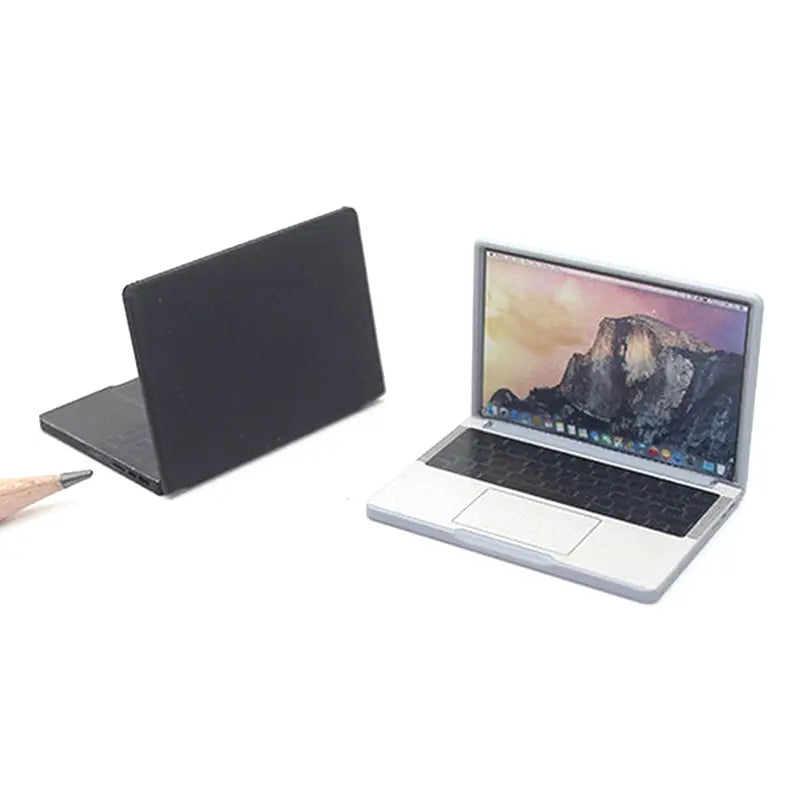 Mini-Laptop aus Silberlegierung mit schwarzer Tastatur und Yosemite-Wallpaper-Bildschirm zur Verwendung als Puppenhauszubehör.