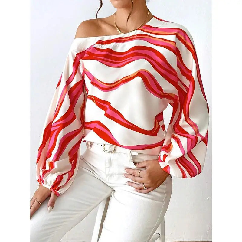 Slash neck off shoulder satin blouse with vibrant bold wavy stripes in shades of red and pink featuring an elegant sleeve style.