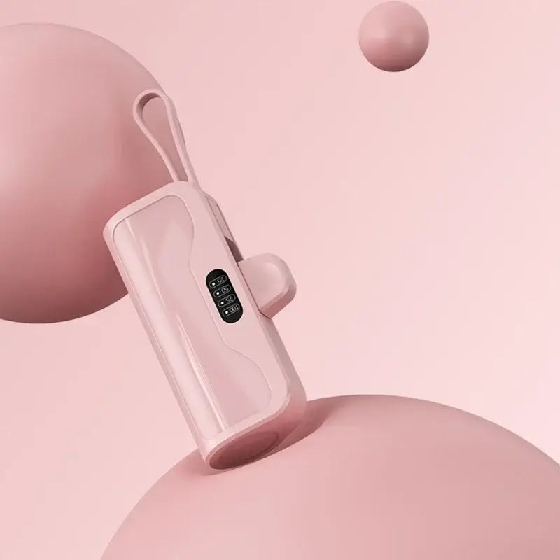 Un masajeador de mano de plástico rosa con diseño moderno y elegante y un pequeño panel de pantalla digital, presentado junto a un mini cargador portátil de banco de energía de carga rápida en net zh-cn.