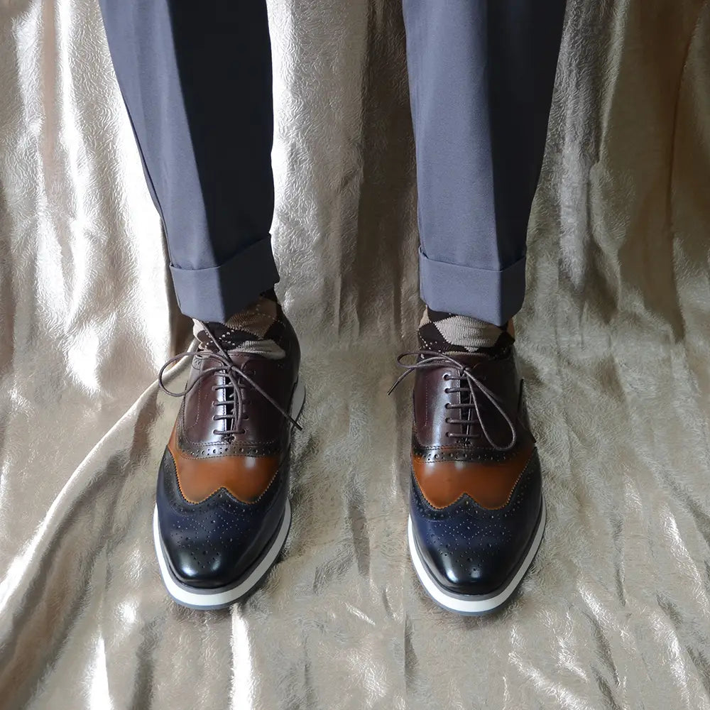 Escarpins brogue wingtip en cuir marron et bleu marine bicolore, avec des accents en cuir camel.