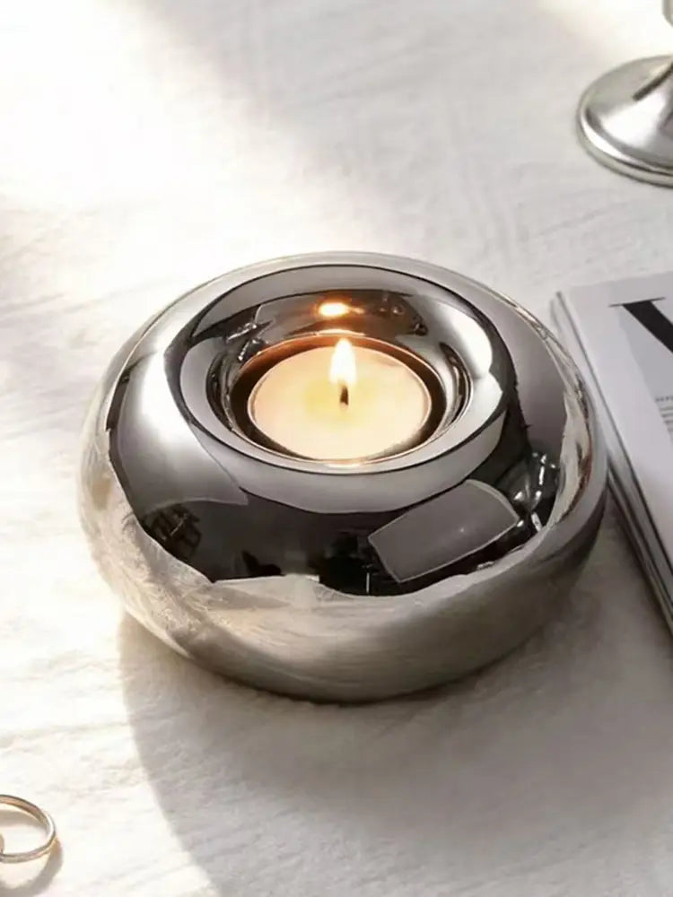 Silver ceramic sphere candle holder with a shiny metallic finish smooth rounded design and reflective surface.
