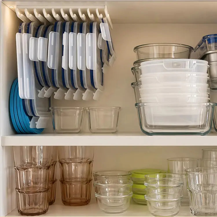 Porte-couvercles de rangement en plastique blanc et bleu, contenant plusieurs couvercles de boîtes de rangement alimentaire, conçu pour un rangement peu encombrant et organisé des couvercles.