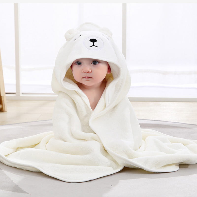 Serviette de bain pour bébé à capuche blanche à thème ours polaire, en matière pelucheuse douce, avec des traits du visage brodés.