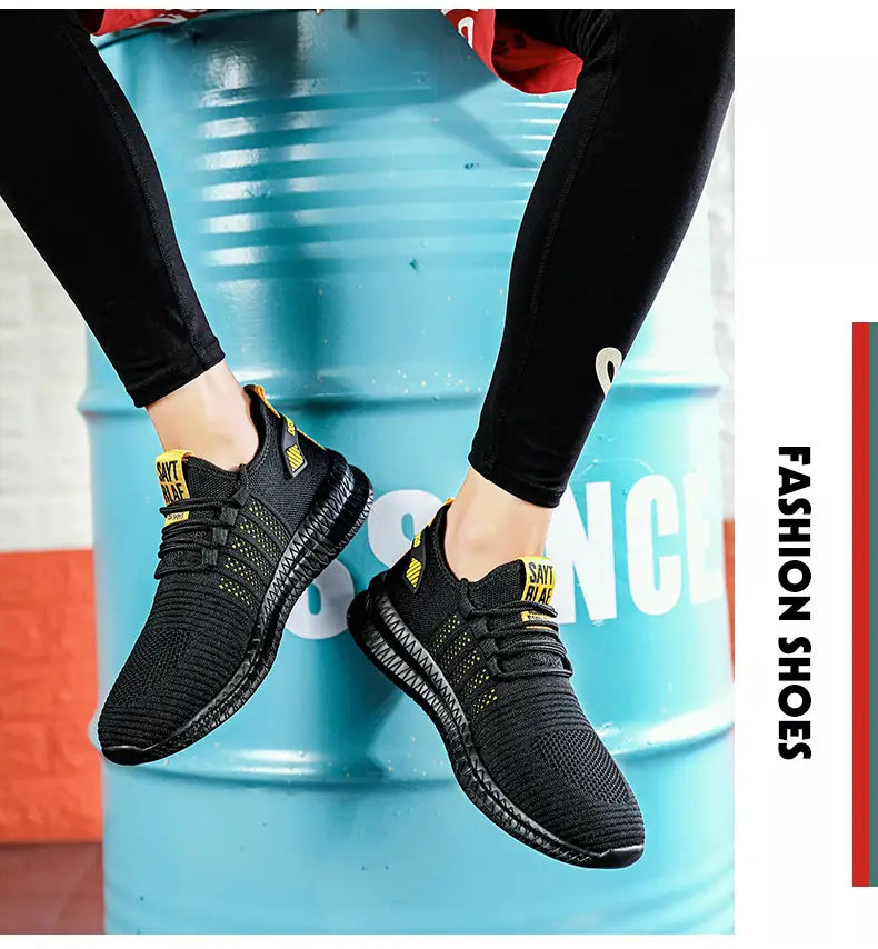 Herren-Atmungsaktive legere Strick-Sneaker aus schwarzem Mesh mit gelben Akzenten und einer strukturierten Gummisohle.