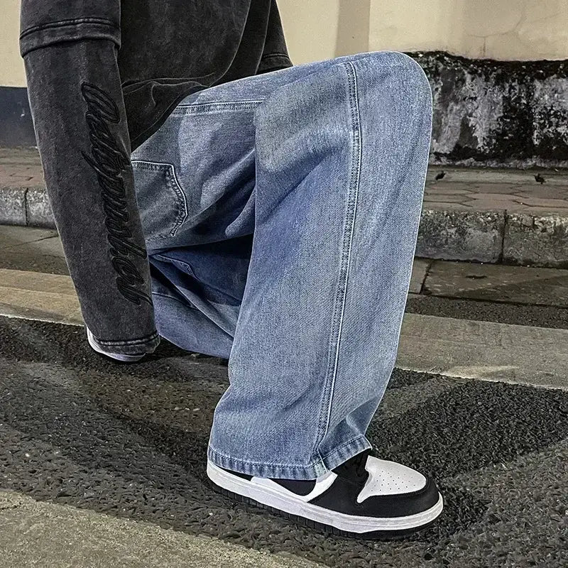 Jeans à jambes larges en denim à lavage clair pour hommes, avec une coupe décontractée à jambe droite et des détails de surpiqûres visibles, idéals pour un streetwear coréen ample.