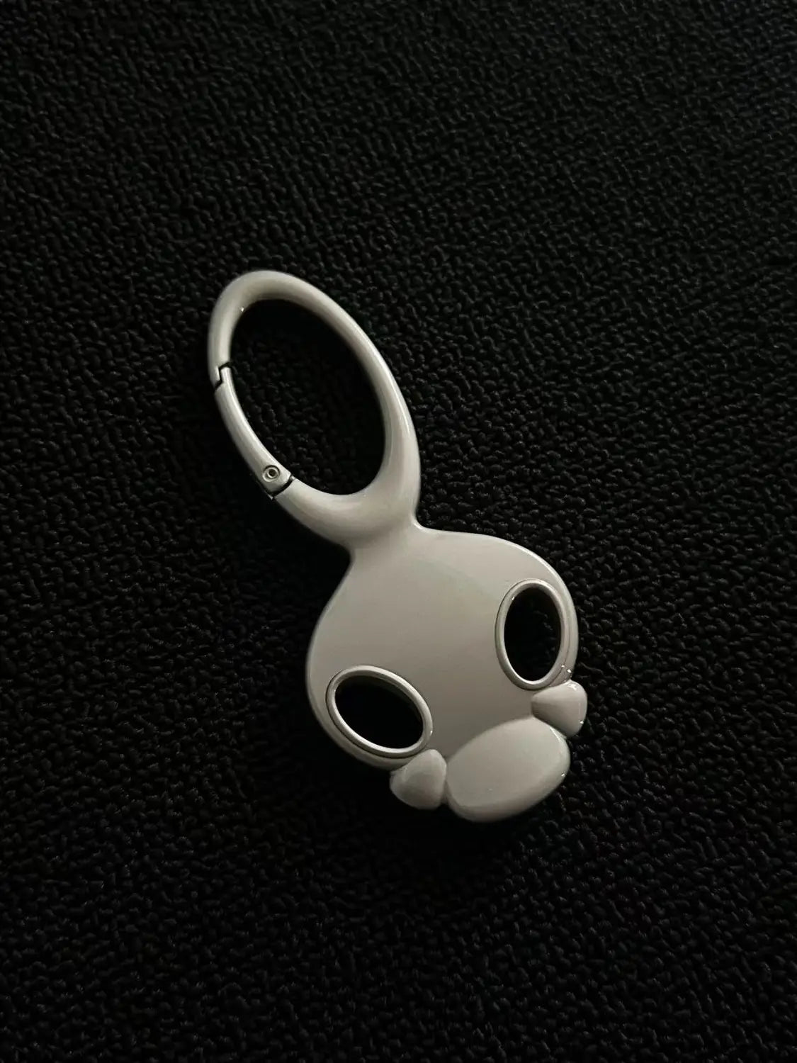 a sleek matte white bunny-shaped keychain made of metal with a polished ring and snap closure designed as a skull metal car keychain bag charm