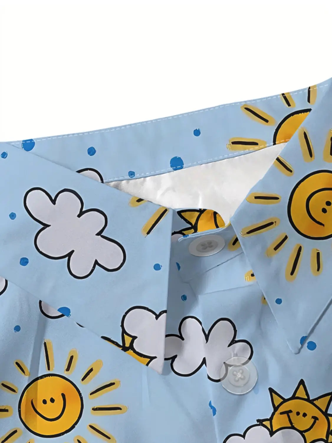 hellblaue Damen-Freizeitbluse aus Polyester mit Knopfleiste, mit einem fröhlichen Muster aus lachenden gelben Sonnen, weißen Wolken mit schwarzen Konturen sowie verstreuten blauen Punkten.