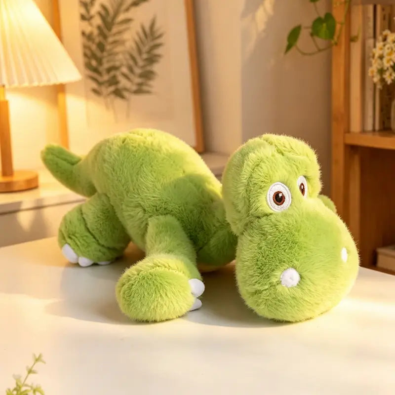 Un jouet peluche de dinosaure coloré vert citron doux avec des yeux blancs et de petites pattes blanches fabriquées en matériau de peluche.
