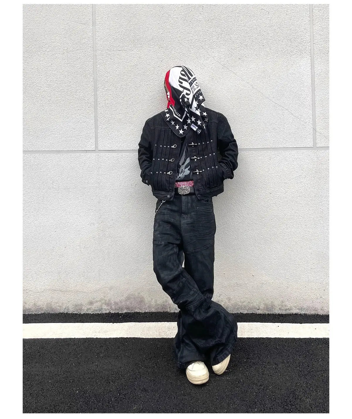 Veste en denim noire avec des clous argentés et un détail de fermeture éclair, associée à des jeans empilés en denim noir Y2k vintage pour hommes dans une tenue décontractée élégante
