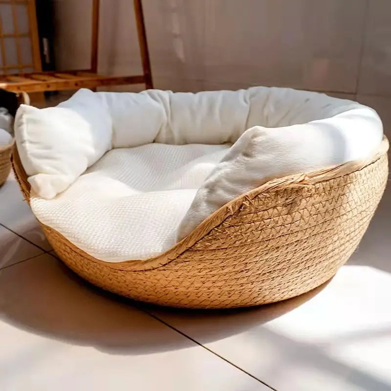 A cozy round cat bed sleeping bag with a woven natural paper rope exterior and plush white cushioning for comfortable pet rest.