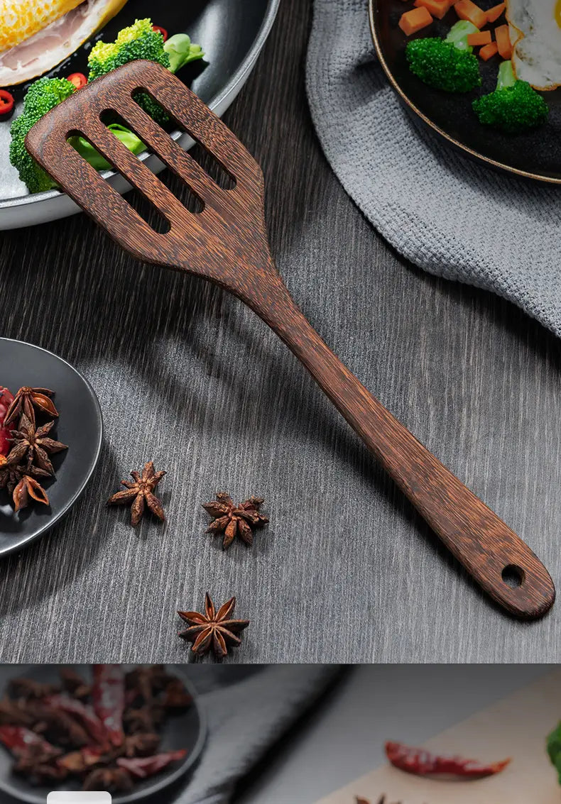 A dark brown wooden spatula with a smooth polished finish and three elongated slots from a wooden kitchen utensil set designed for non-stick cookware.