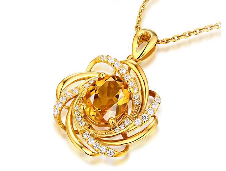 Collier pendentif moulin à vent en citrine doré en or comportant une citrine ovale centrale entourée de bandes dorées tourbillonnantes, avec de petits diamants, sur une chaîne dorée assortie.