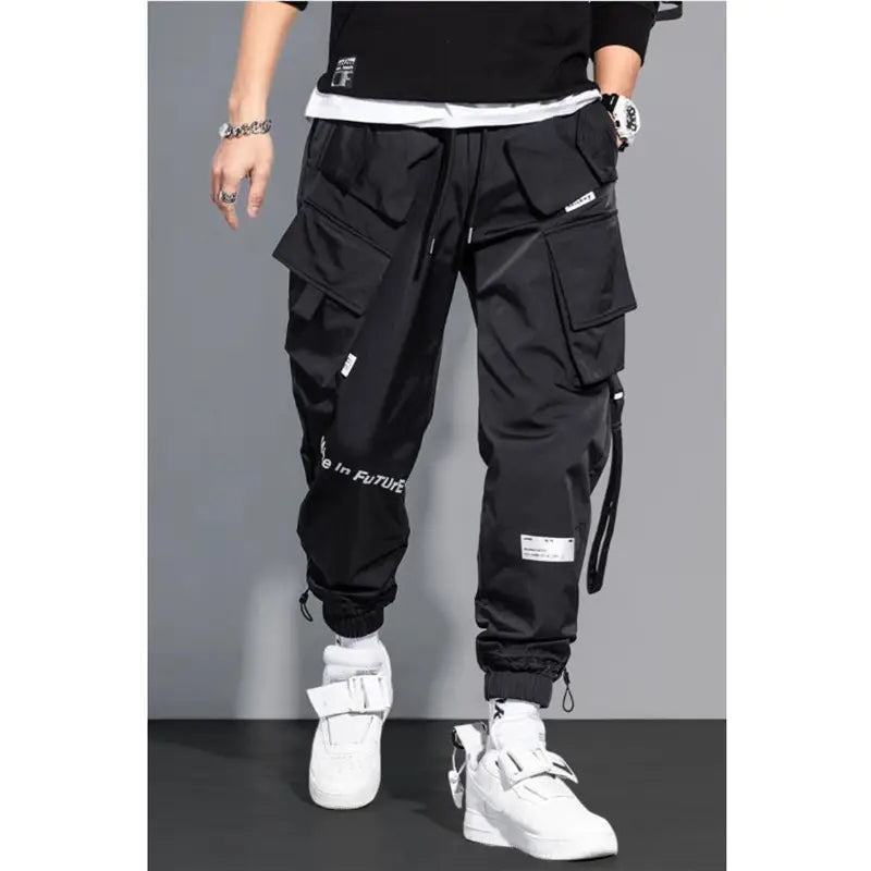 Black teal mens tactical cargo pants feature multiple pockets, a drawstring waistband, and white text on the leg for streetwear use.