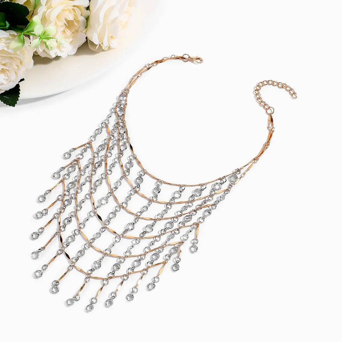 Un délicat collier ras du cou à gland en cristal en or rose, avec des niveaux en cascade de cristaux transparents et des chaînes métalliques fines.