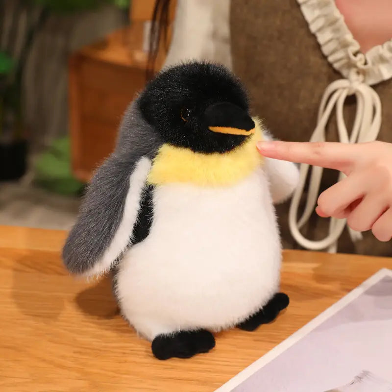 A plush penguin stuffed animal soft toy pair featuring black white and yellow fur made from soft material.