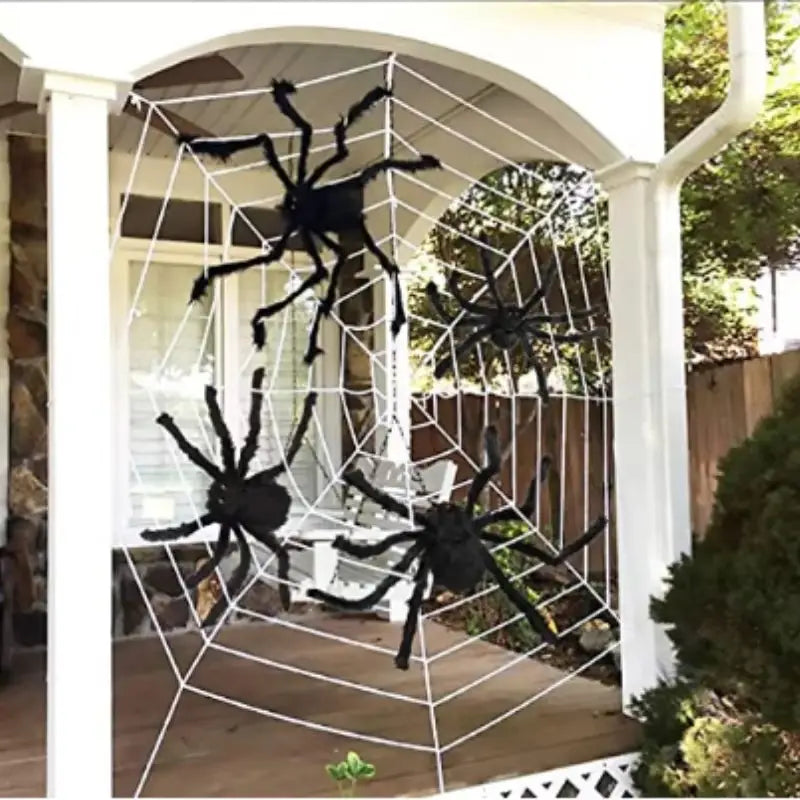 fausses araignées en plastique noires positionnées sur une décoration de toile d’araignée blanche pour des décorations d’Halloween, vues de face