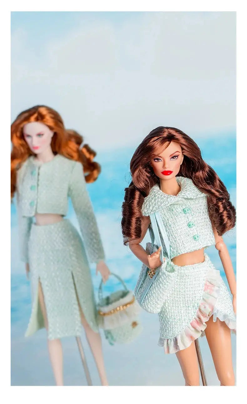 Ensemble de vêtements et d’accessoires de mode pour poupée à l’échelle 1/6, comprenant une poupée Barbie aux longs cheveux bruns ondulés portant un haut court en tweed vert menthe clair et un ensemble de jupe assorti, rehaussé de volants roses à l’ourlet.