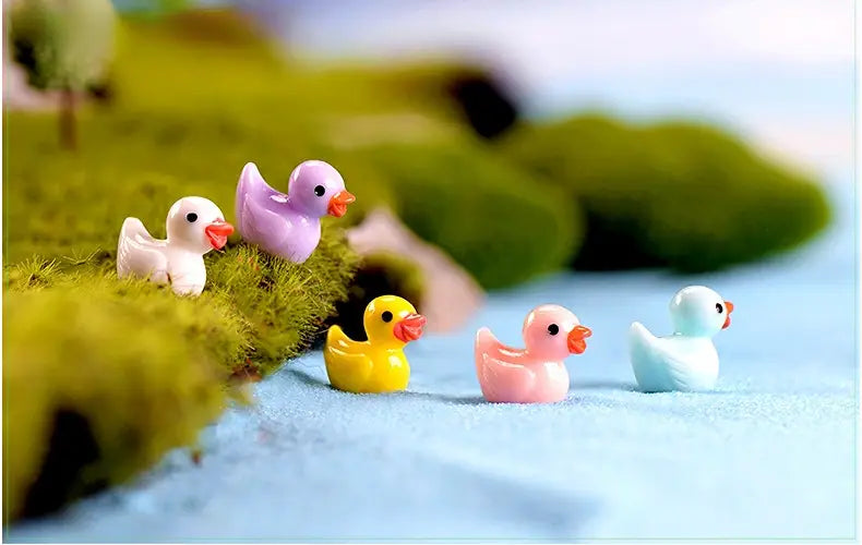 Une collection de figurines miniatures en résine de lapin dans des couleurs pastel, comprenant blanc, violet, jaune, rose et bleu clair, conçue pour la décoration d’un jardin féerique.
