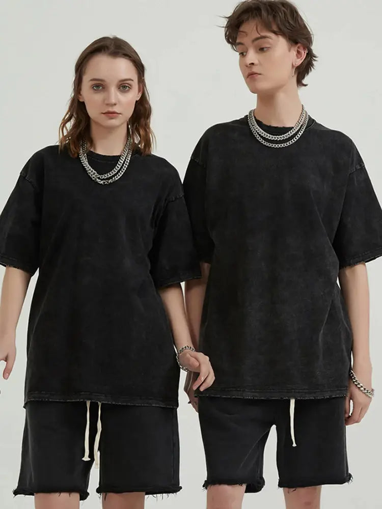 Camiseta negra extragrande con ajuste relajado y dobladillo deshilachado y desgastado, con un gráfico gótico de anime en tela de algodón vintage lavada y desteñida.