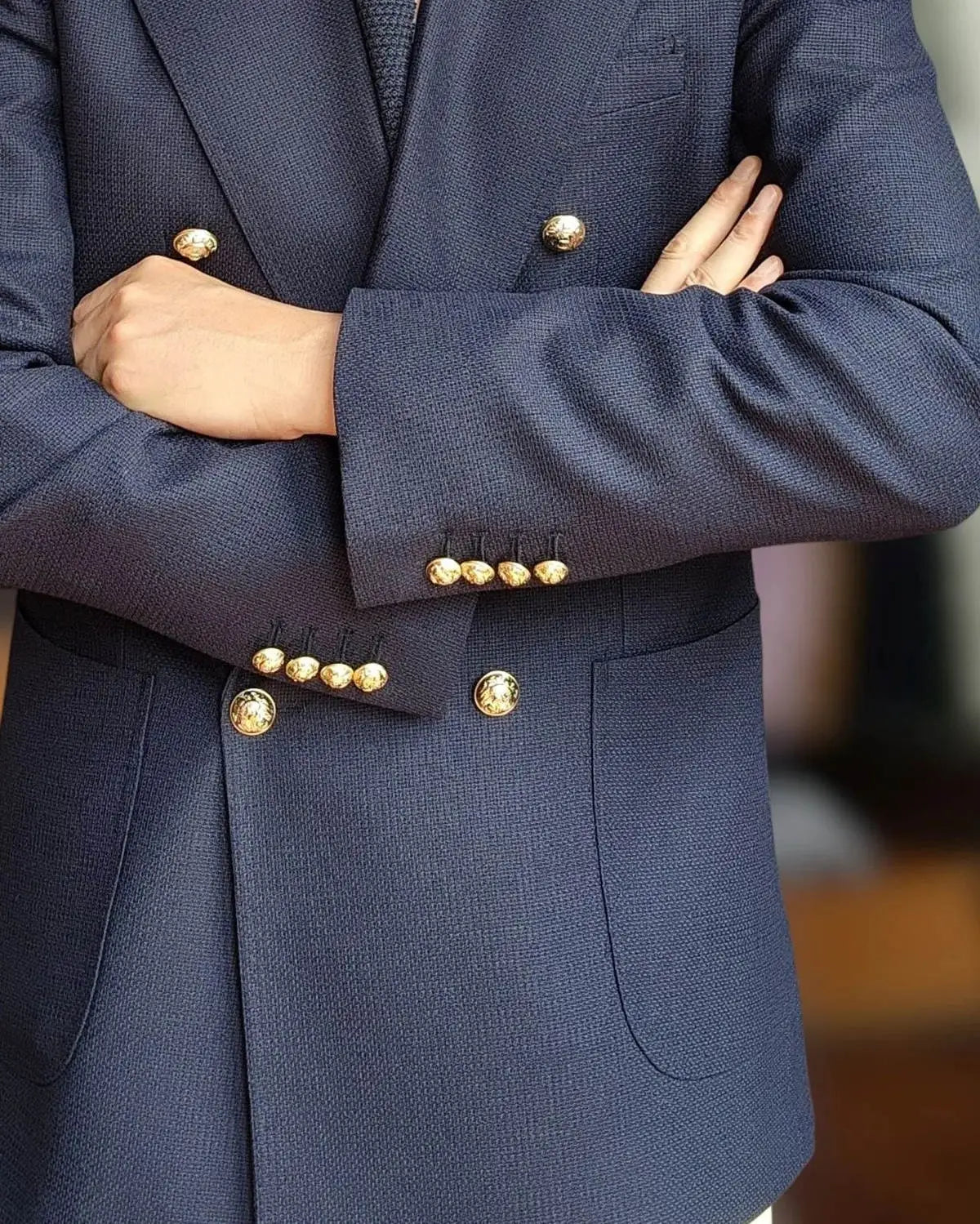 Veste de smoking pour marié bleu marine à double boutonnage, avec boutons ton or et type de fermeture à double boutonnage.