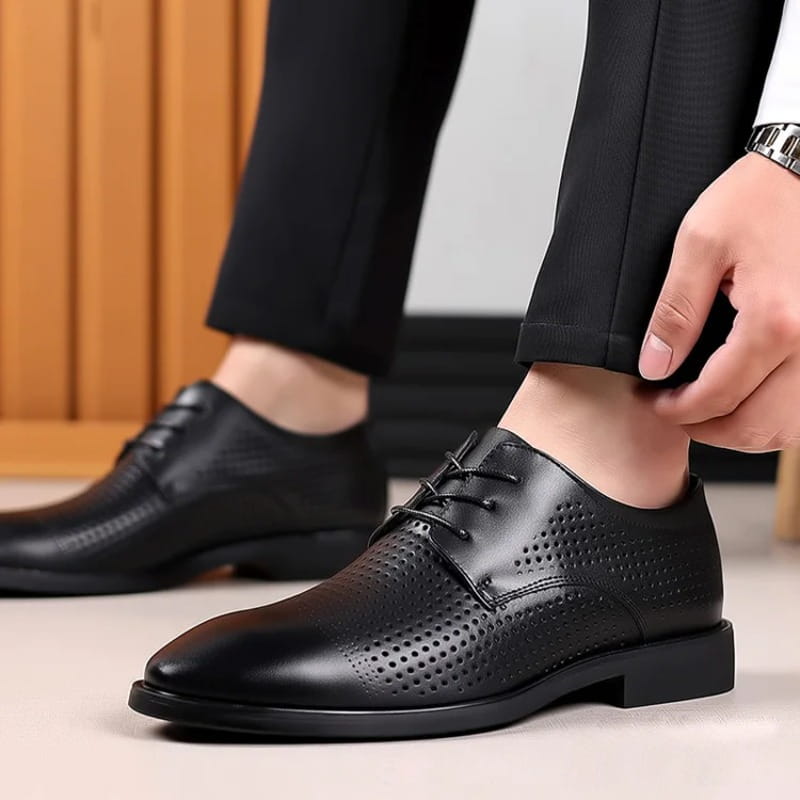 Herren-Oxford-Kleiderschuhe aus weißem Leder, dargestellt als schwarze, geschnürte Kleiderschuhe aus Leder mit perforierten Details und einem niedrigen Blockabsatz.
