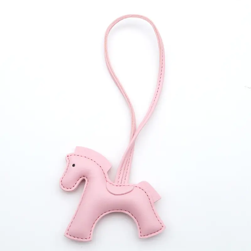 Porte-clés en cuir rose délicat en forme de cheval avec lanière-boucle assortie, conçu dans le style du porte-clés iconique en forme de cheval d’Hermès’.