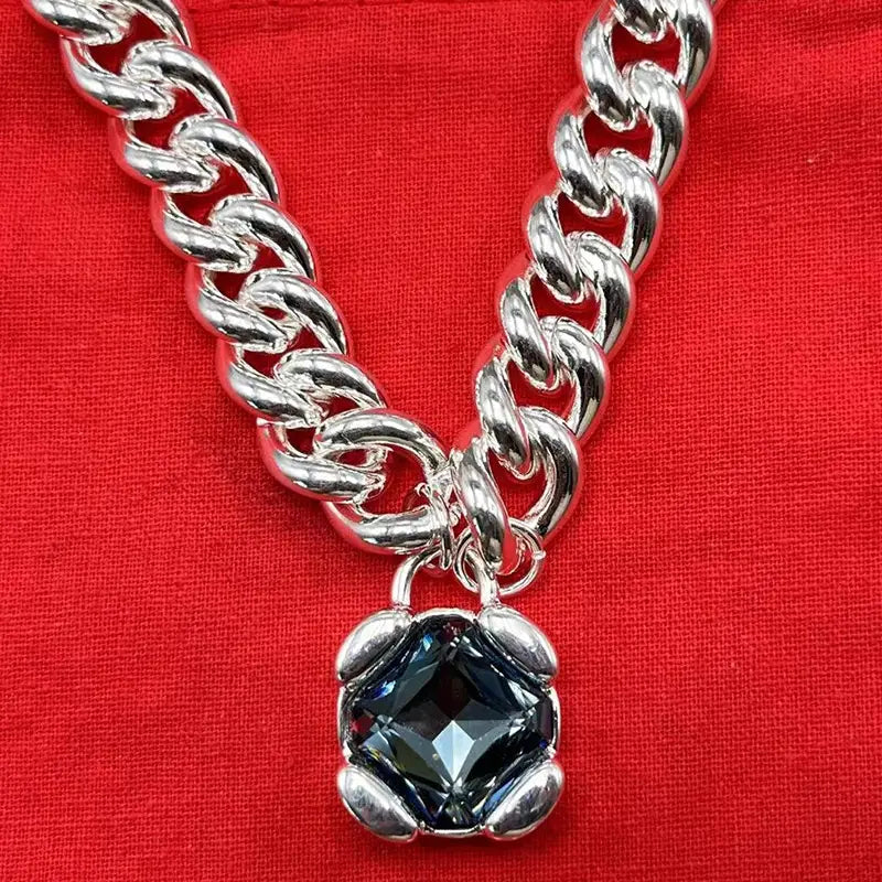 Silver chain necklace with a dark blue faceted crystal pendant in a silver-toned metal frame from the crystal pendant jewelry set gold and silver tone.